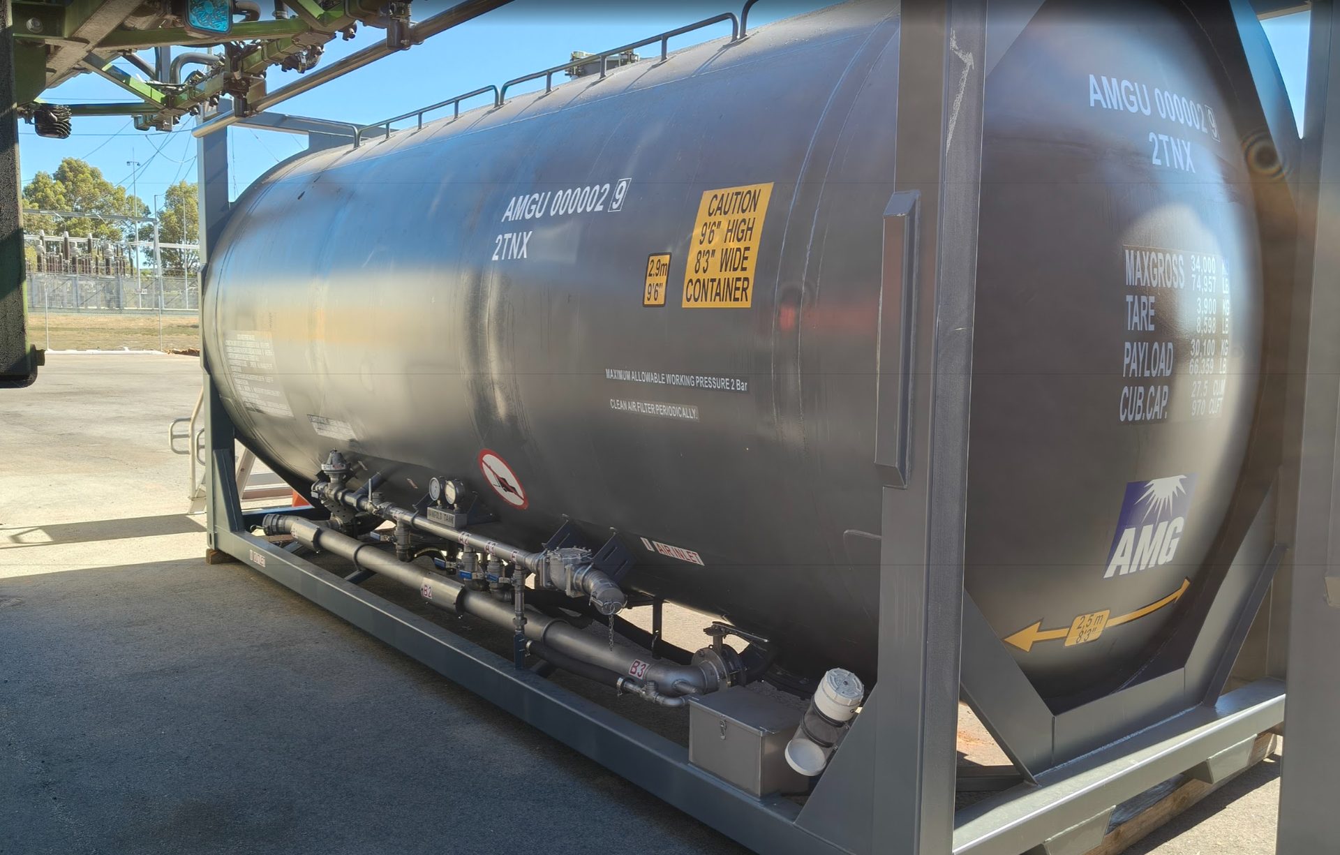 The AMG Pressure Tanker ISO under a loading gantry at a Western Australian site, with its manifold, lockable toolbox and outlet visible